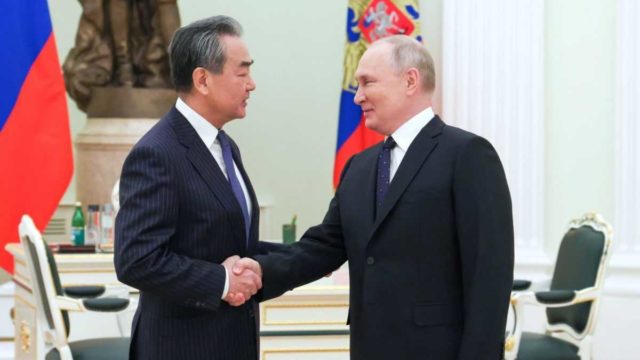 Vedoucí ústřední komise Komunistické strany Číny pro zahraniční vztahy Wang I (vlevo) a ruský prezident Vladimir Putin během setkání v Moskvě ve středu 22. února 2023. 