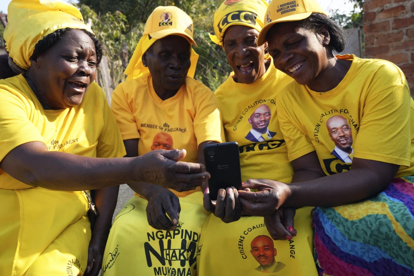 Čtyři babičky v zářivě žlutých šátcích, tričkách a sukních se choulily kolem mobilního telefonu v zimbabwské venkovské oblasti Domboshava. 